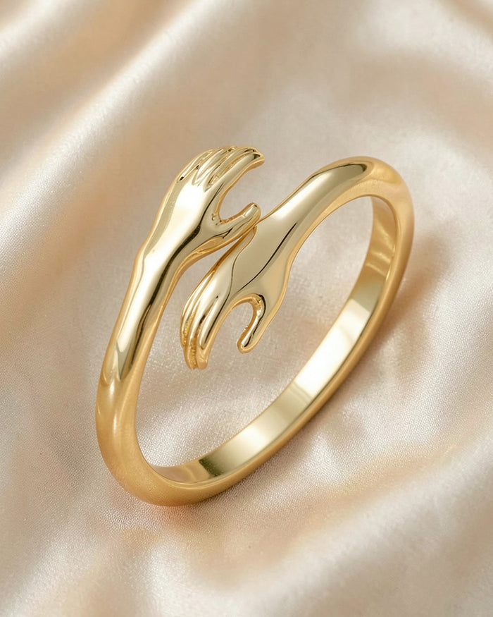 The Hug ring in gold on ivory silk