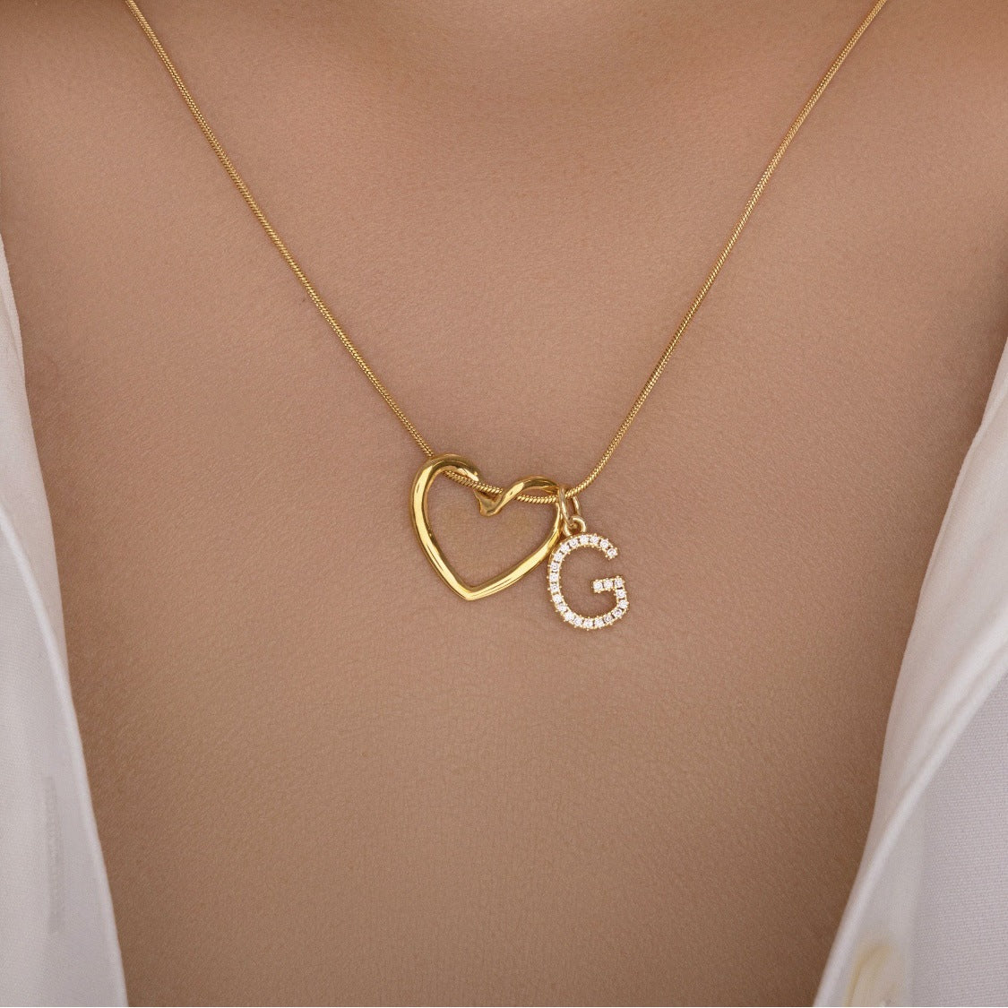 The Keepsake Heart necklace worn at the collarbone, initial G