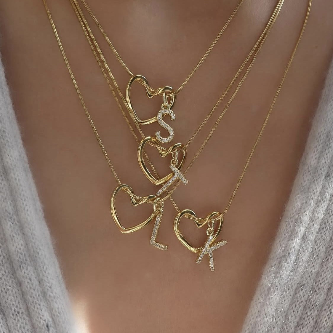 Four Keepsake Heart necklaces layered, with initials S, T, L and K