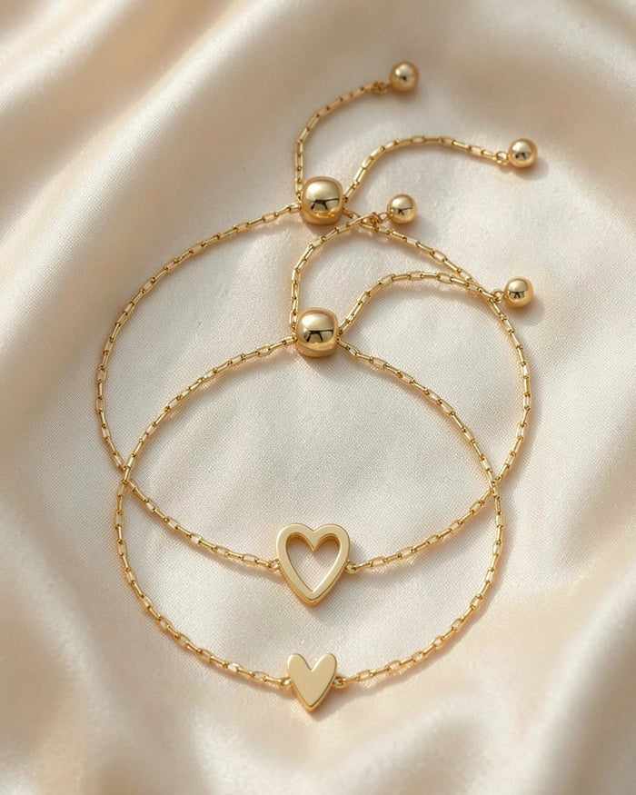 The Heart Chain bracelet pair in gold, open heart and small heart, on silk