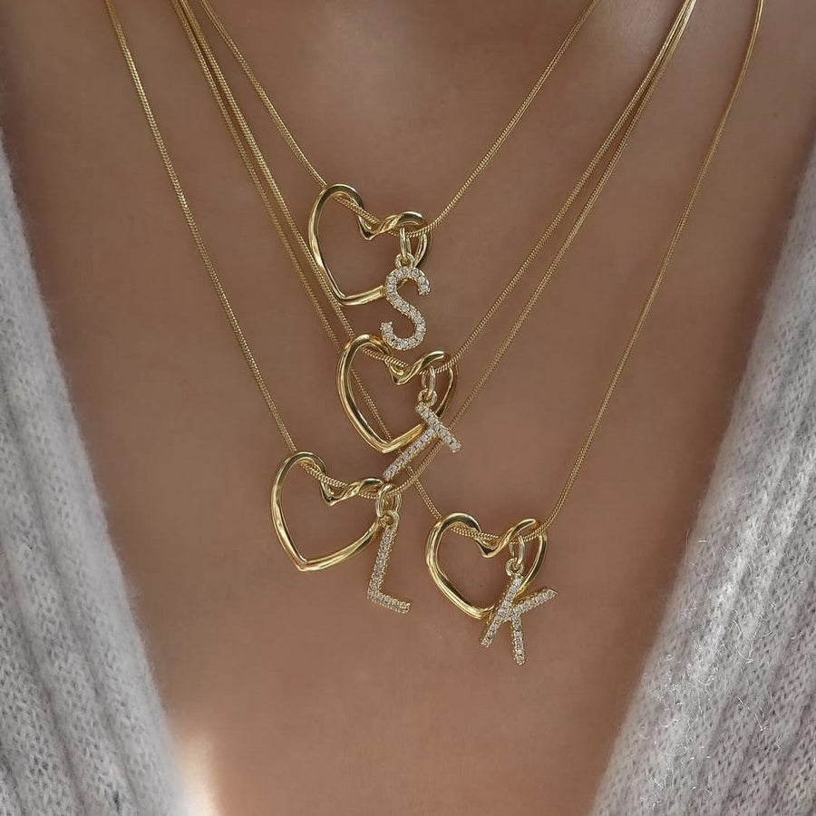 Four Keepsake Heart necklaces layered, with initials S, T, L and K