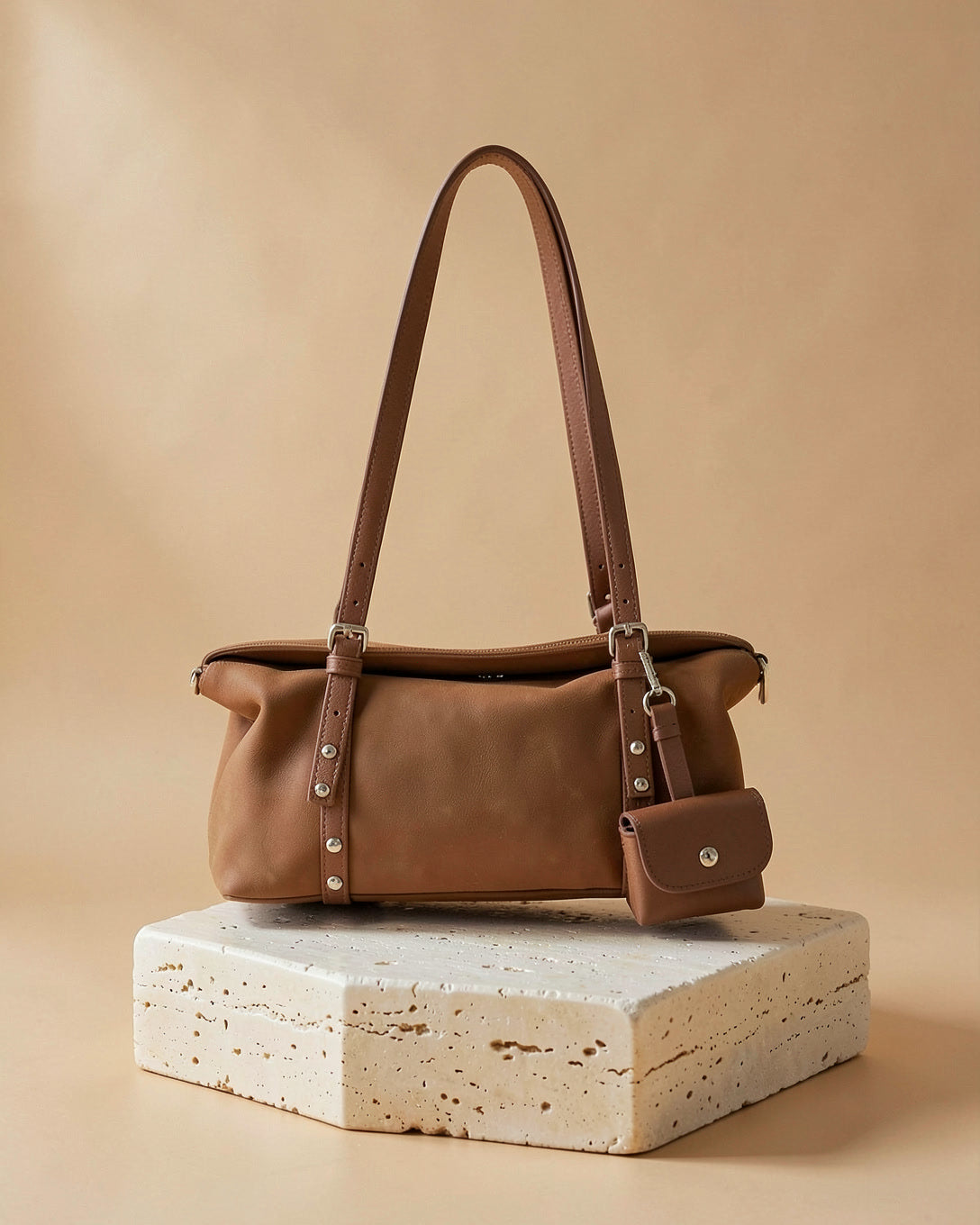 The Frost bag in brown on a travertine block